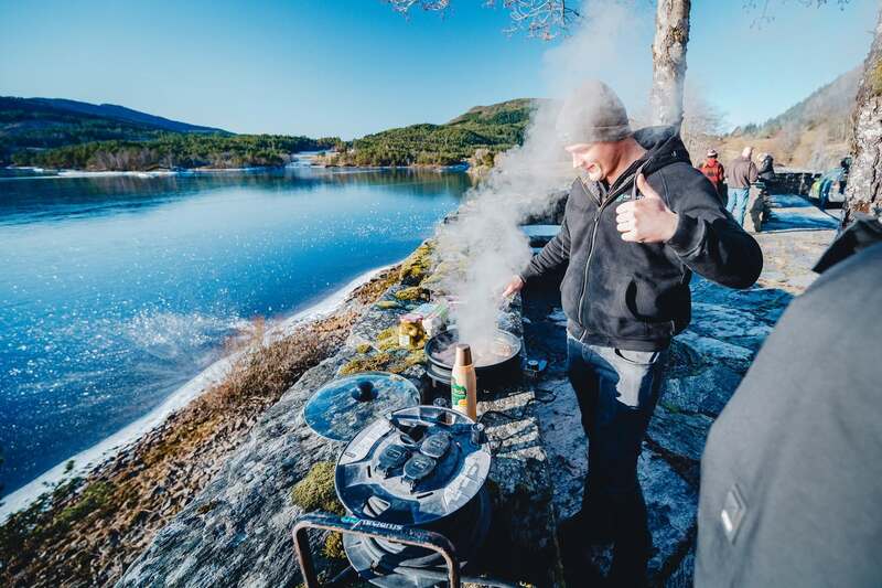 Participant at the campfire by the water during the Carbage Run