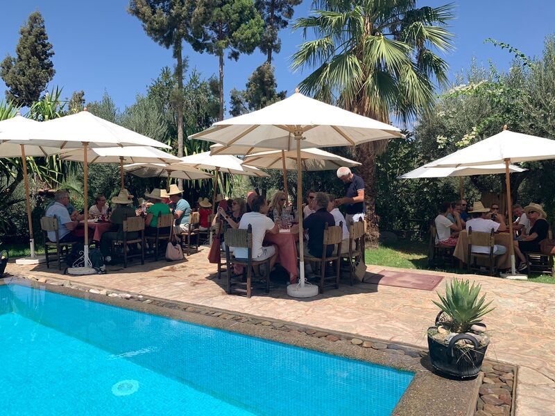 Participants at tables by the pool during a corporate trip
